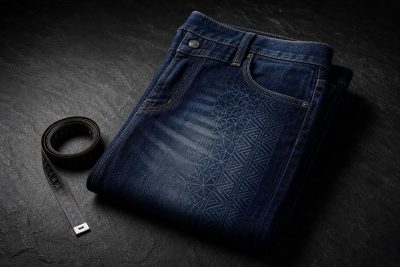 A clean ozone-wash machine drum with indigo jeans inside, soft natural light, minimalist industrial setting, muted indigo and