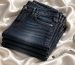 Neatly folded stack of indigo jeans on wooden table with tailor measuring tape in soft natural light